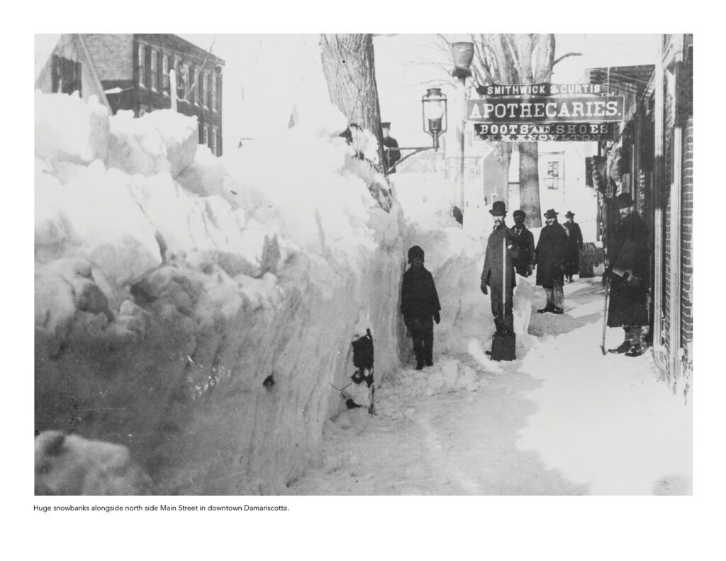 People standing on sidewalk with snowbanks above their heads in Damariscotta, Maine