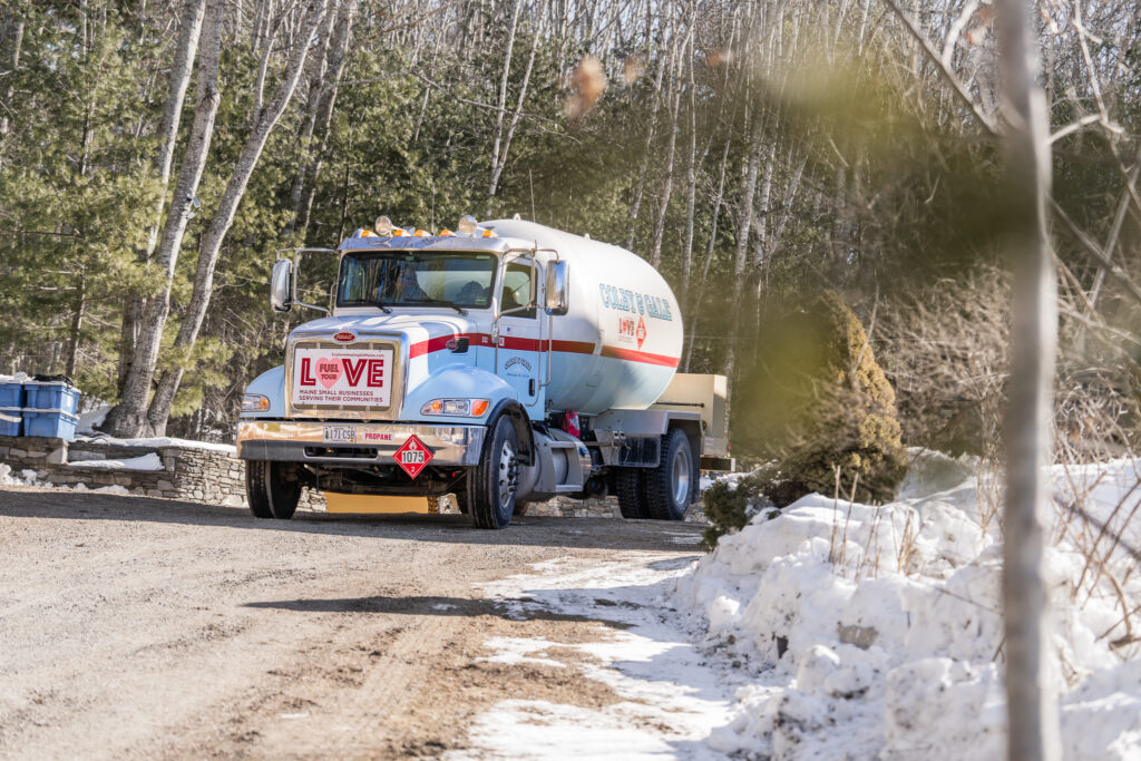 A Colby & Gale fuel delivery truck parked in Boothbay, Maine, featuring a "Fuel Your Love" campaign sign displayed on the front grille.