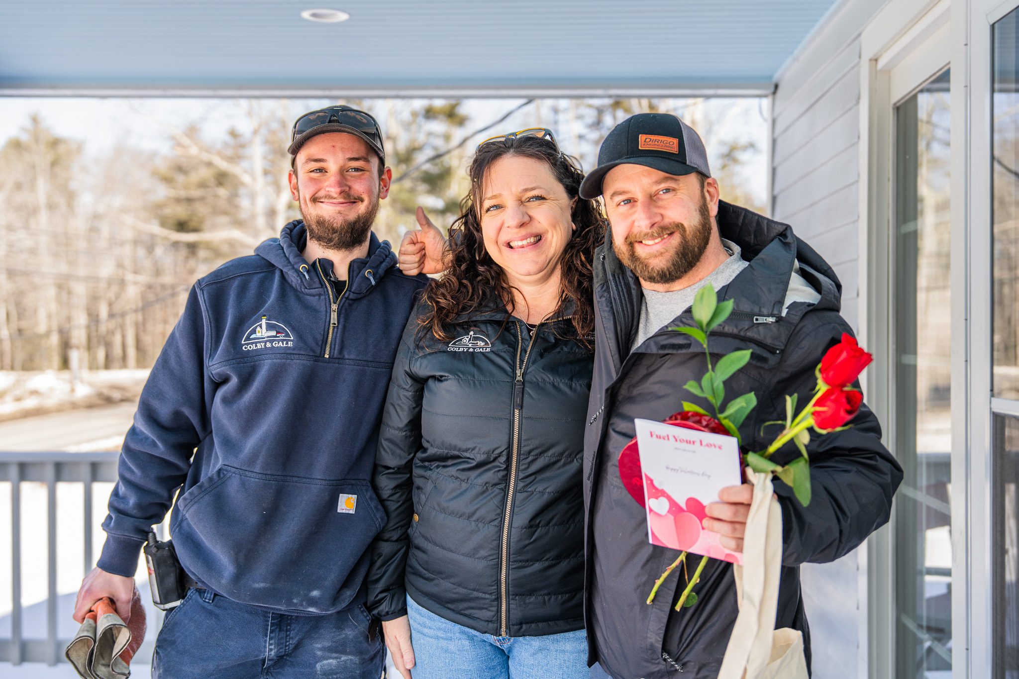 Amanda Reed and Colby & Gale delivery driver Carter Frost standing with a happy customer in front of a residential home after a Fuel Your Love surprise delivery.