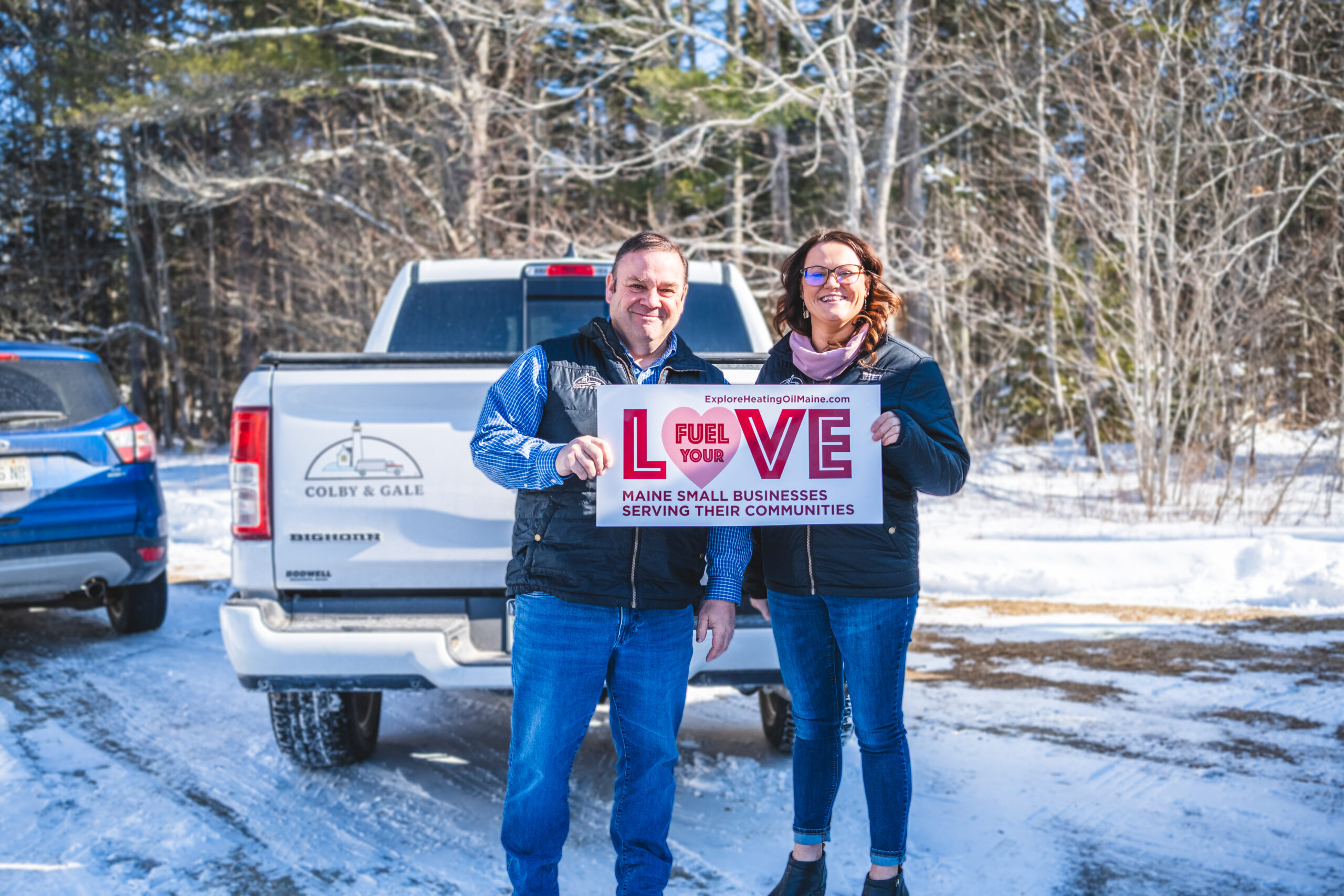 Rob Wilkes and Kelsey Cole holding fuel your love sign.
