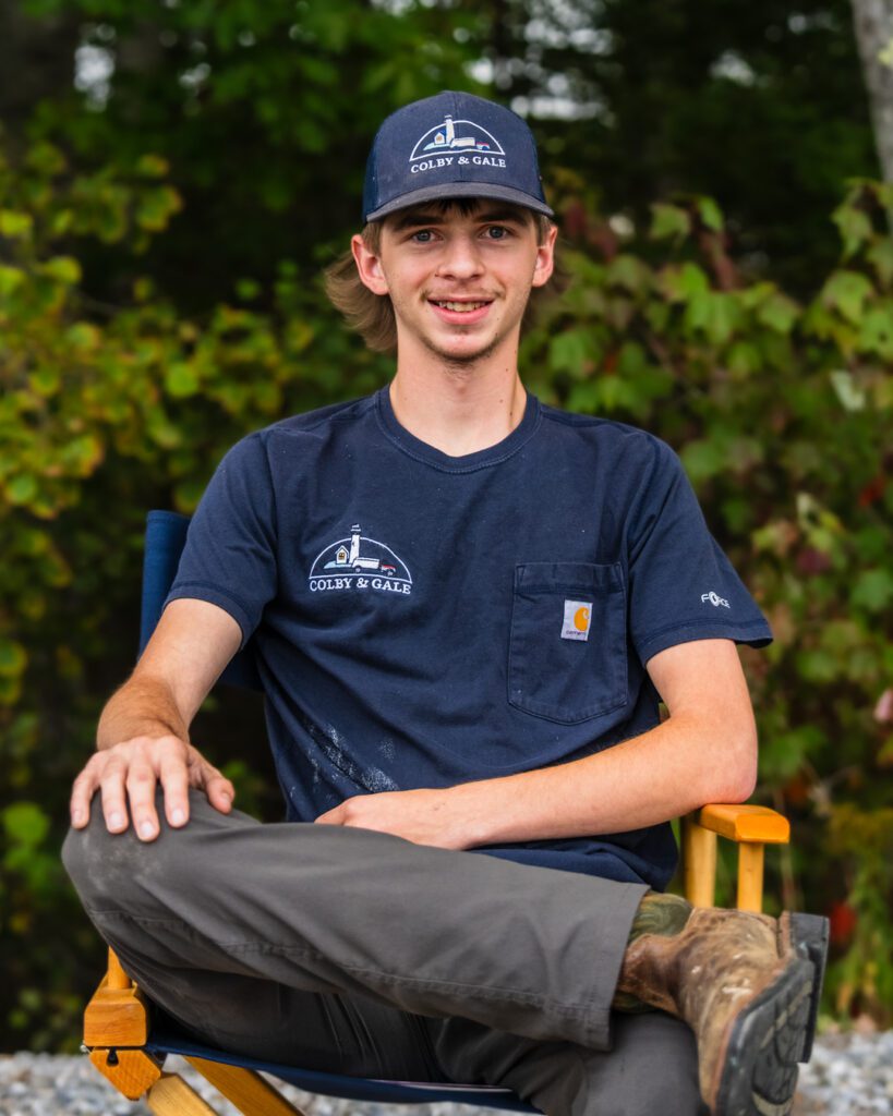 Abraham Blanc sitting in chair with legs crossed and one hand on knee