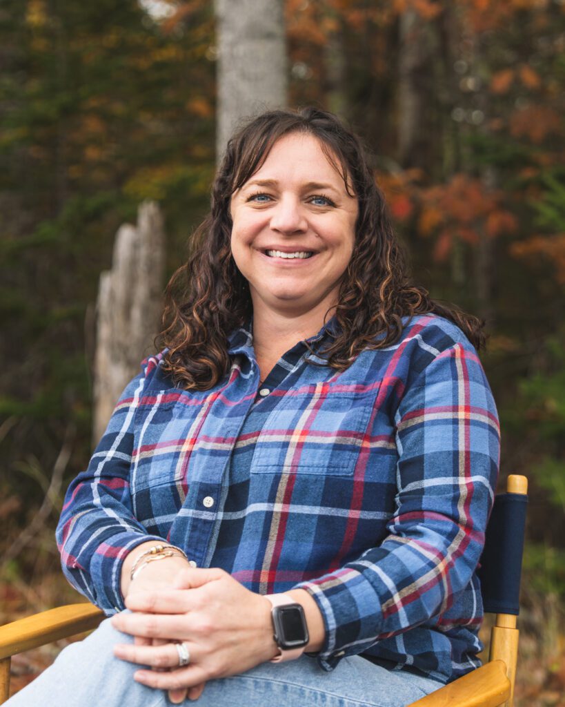 Amanda Reed sitting in chair with hands clasped on knees. 