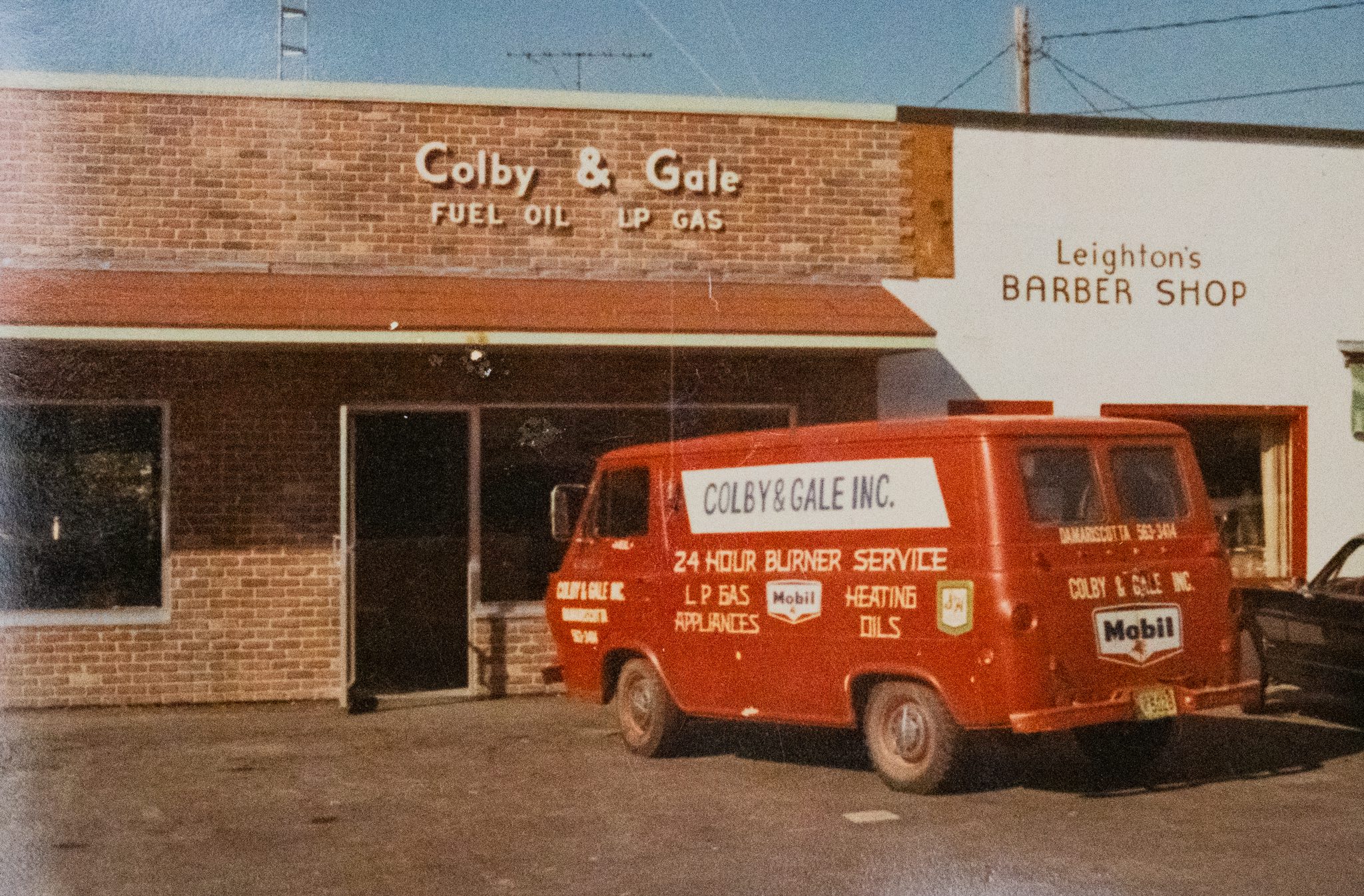 A classic red Colby & Gale service van parked at the Elm Street Plaza office in Damariscotta, Maine, offering heating oil and LP gas services to Lincoln and Knox Counties.