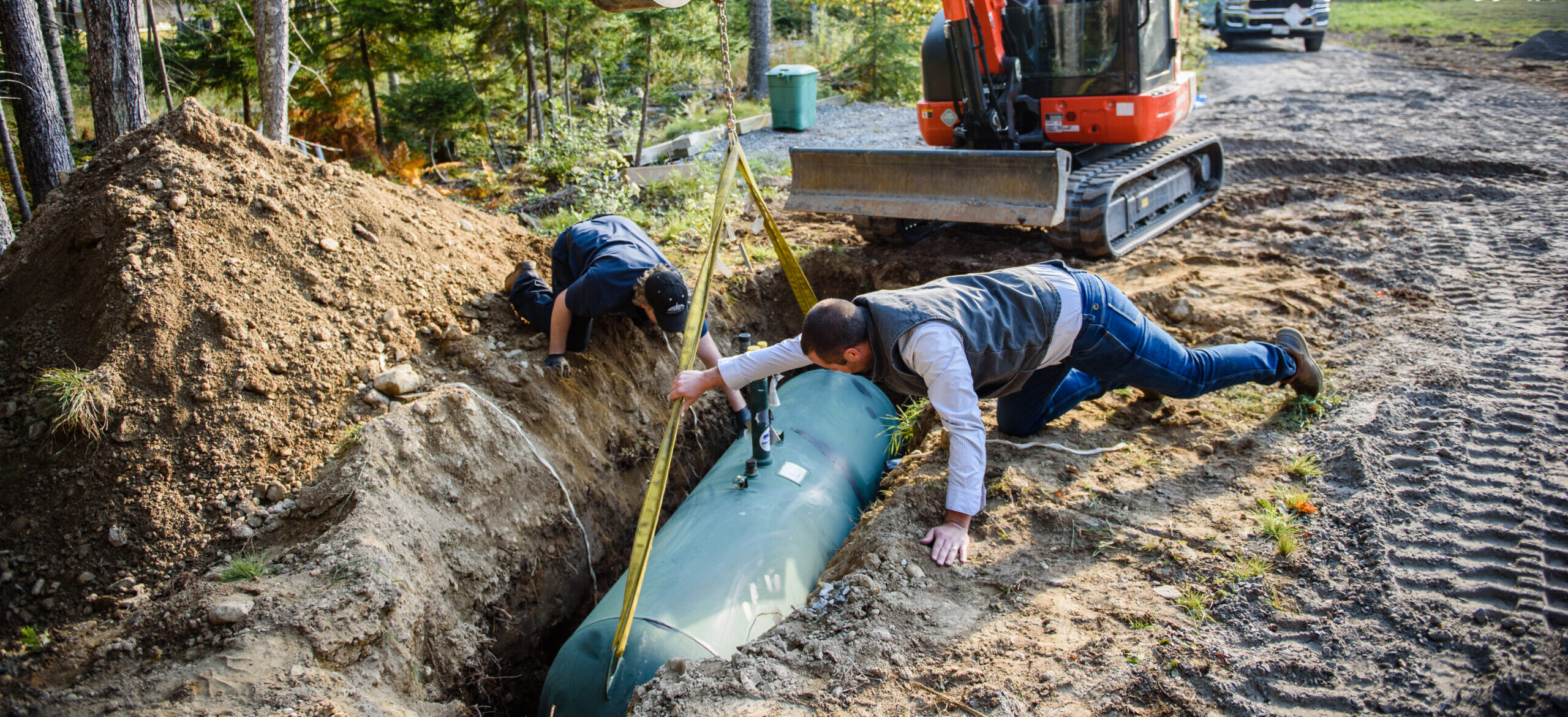 Two Colby & Gale employees installing a underground tank.