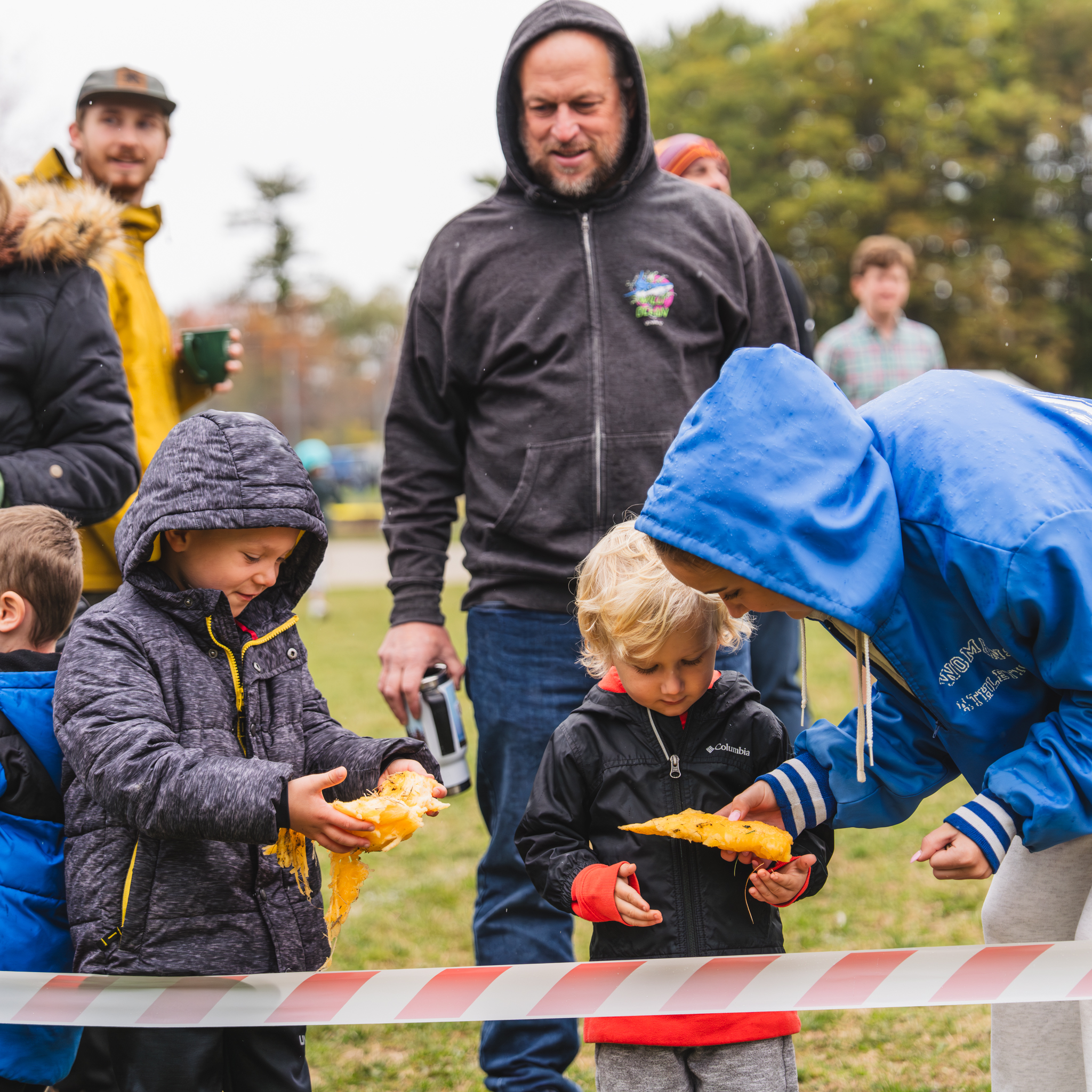 Little kids holding pumpkin pieces from giant pumpkingdrop