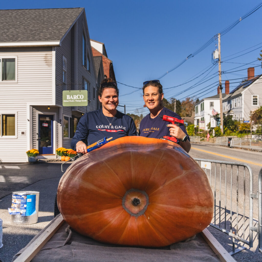 Kelsey Cole and Kristen Dighton posing for photo in front of pumpkin.