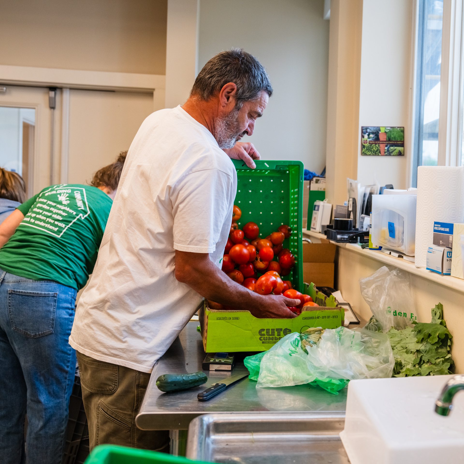 Orville Mooney emptying tomatoes into sink.  