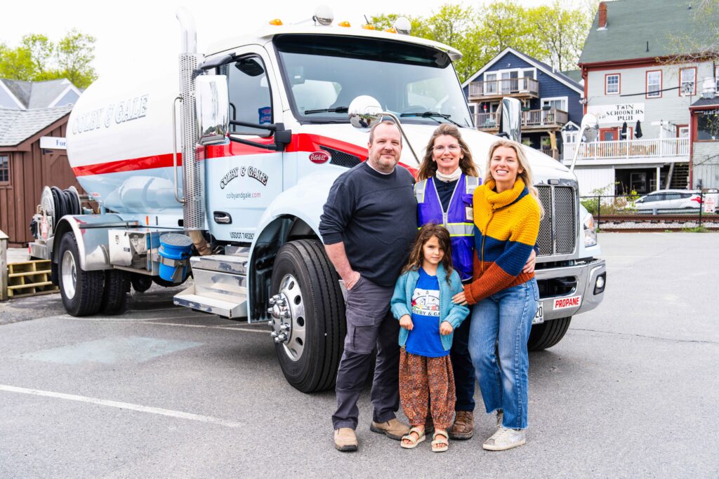 Julie Kuhn taking photo with her family in front of a Colby & Gale propane truck at Sprague's Lobster parking lot. 