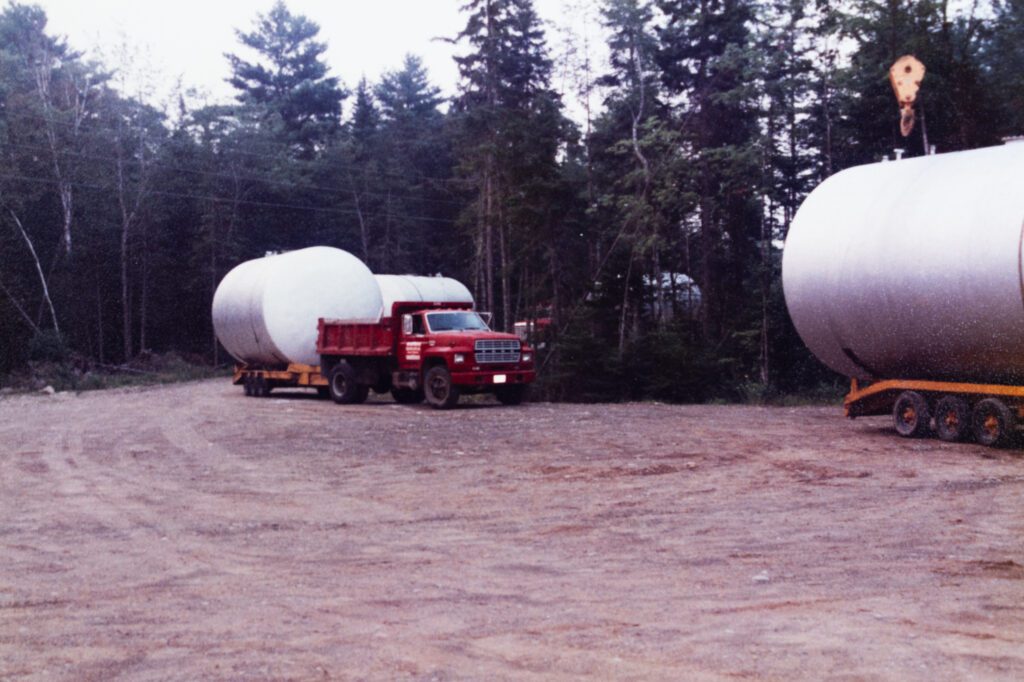 Oil tanks being transported by dump trucks on a flat bed from old Colby & Gale bulk plant location to Biscay Road location in Damariscotta, Maine.