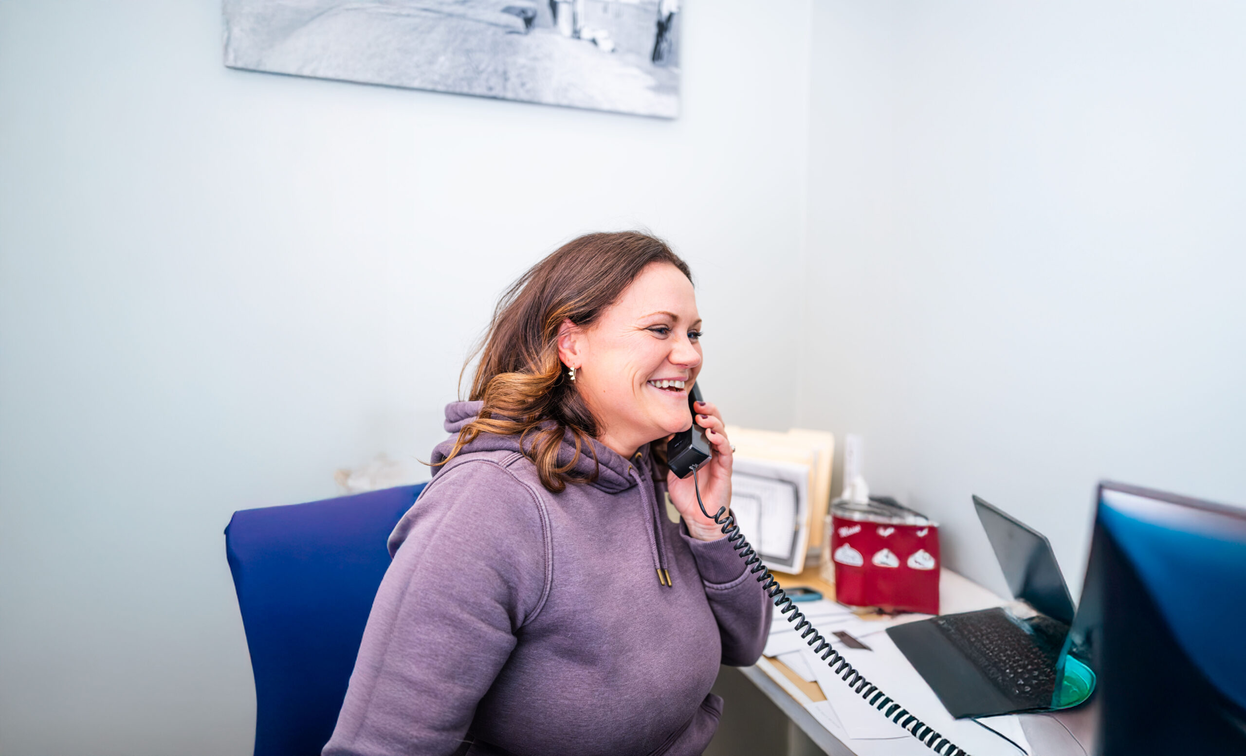 Customer Service Representative Kelsey Cole smiling and talking on the phone