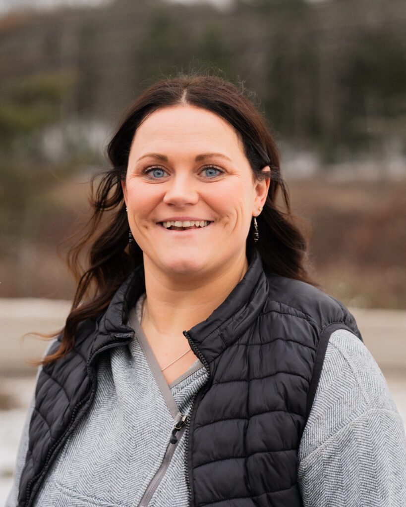 Kelsey Cole smiling and wearing gray shirt and black vest.