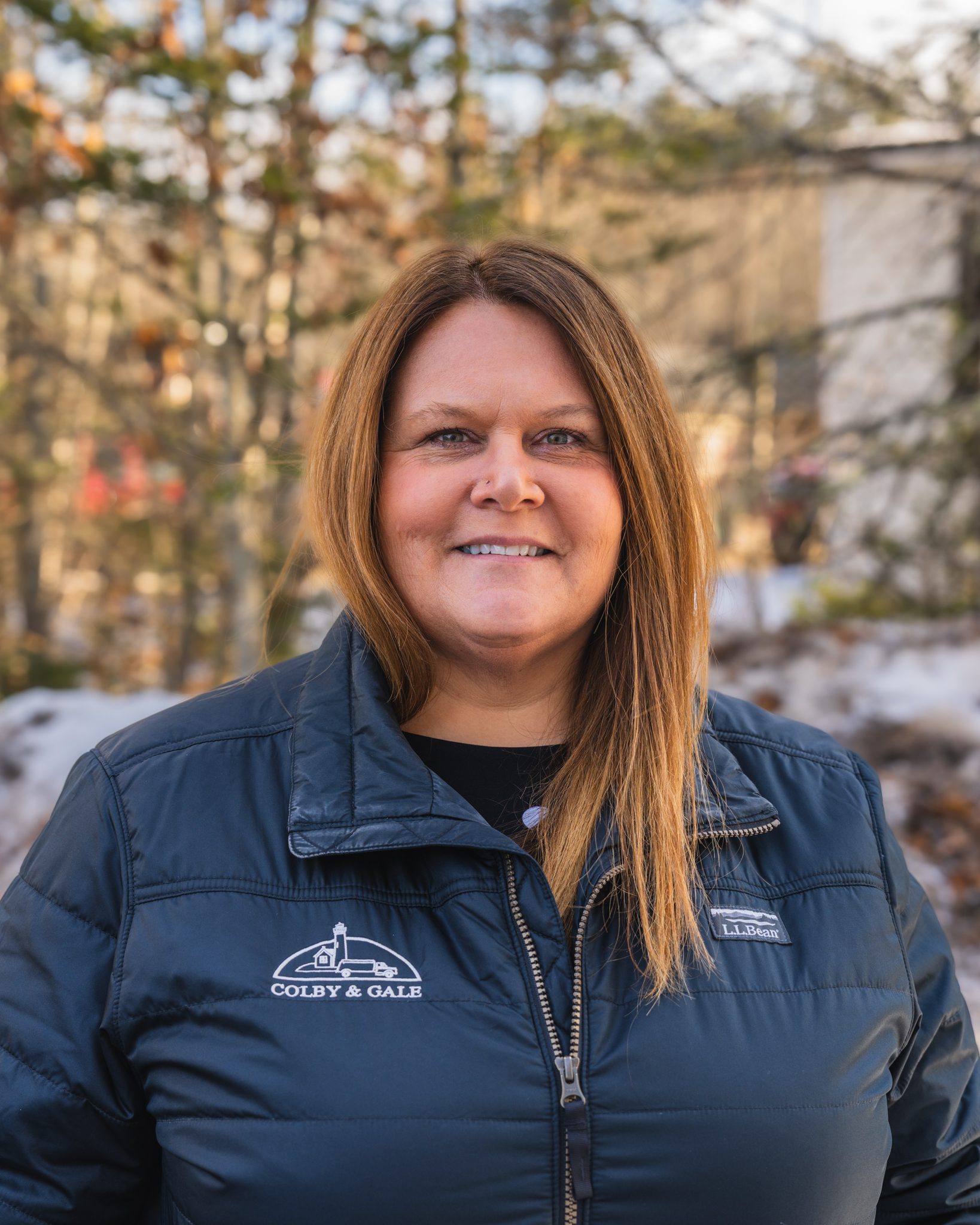 Peggy Whitman, wearing a black Colby & Gale LL Bean jacket smiles at the camera
