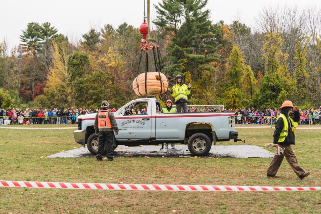 Pumpkinfest workers preparing the giant pumpkin to be dropped on Colby & Gale service truck. 