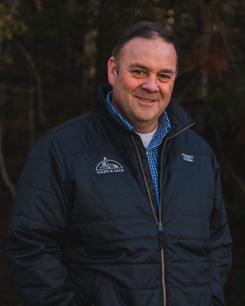 Rob Wilkes smiling with hands in pockets wearing Colby & Gale branded L.L. Bean Jacket