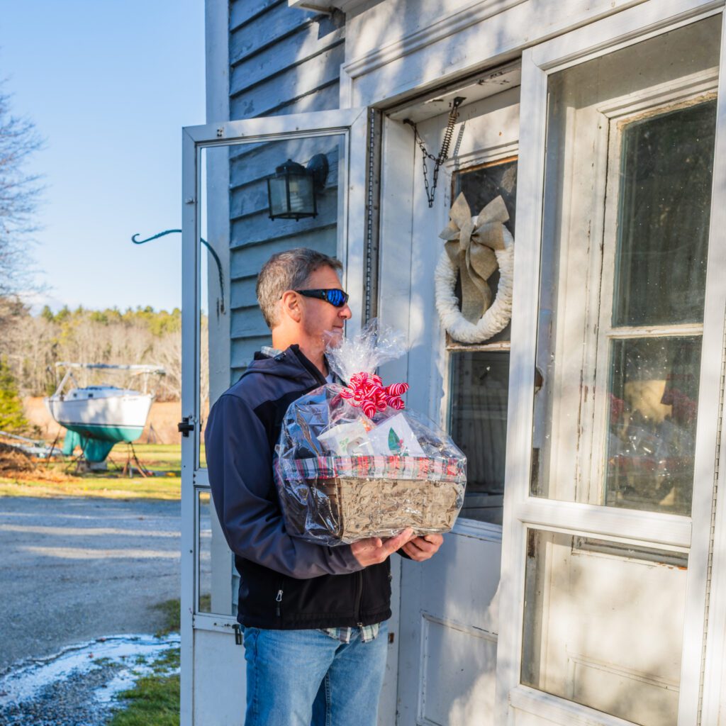 Cappy knocking on customers door with gift basket