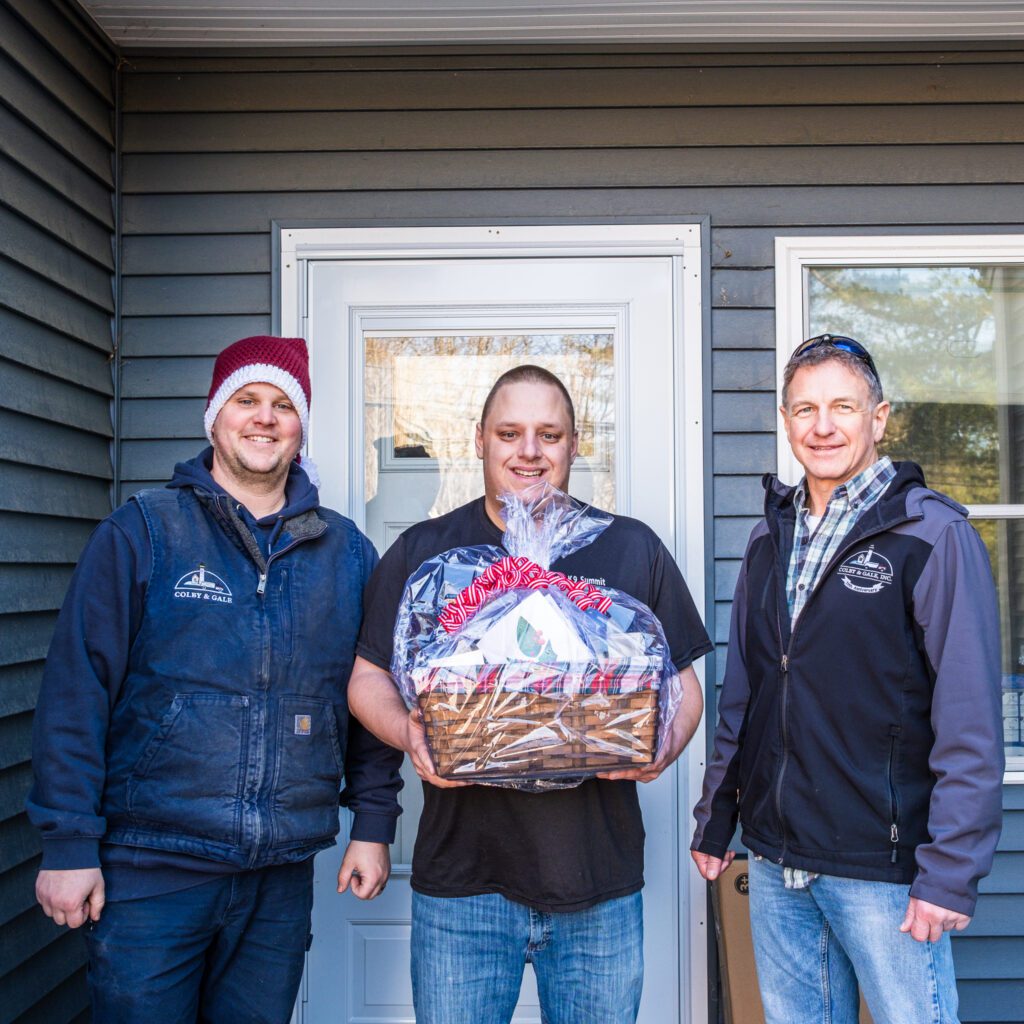 Cappy and Nick posing with customer with gift basket