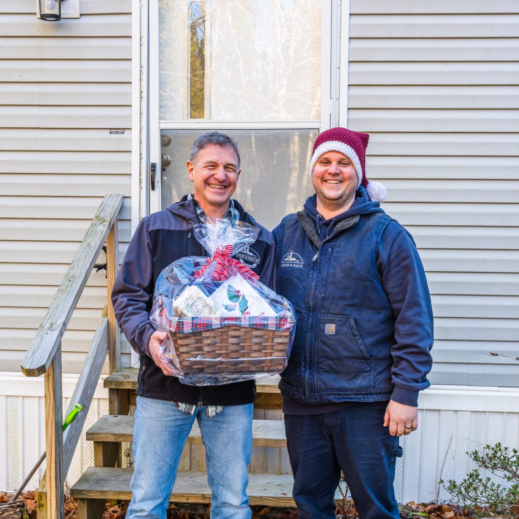 Nick Greanleaf and Cappy Dean smiling and holding gift basket.